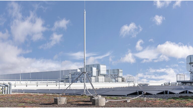 HVI Fangmast im Dreibeinstativ montiert mit isolierter HVI Leitung auf begrüntem Flachdach. 